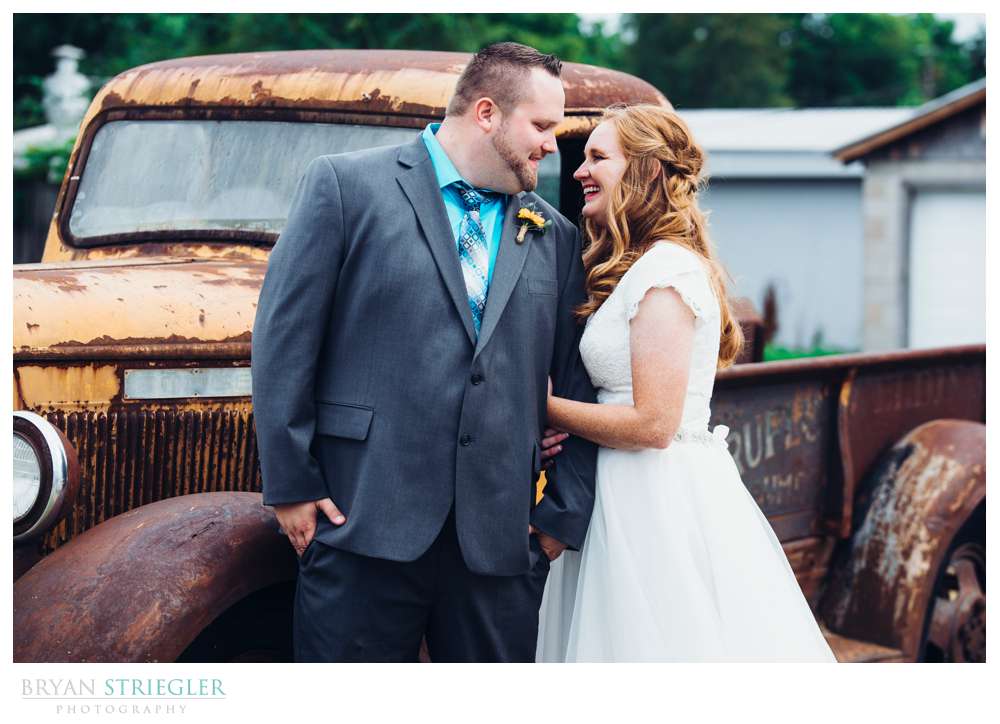 bride and groom in front of old truck